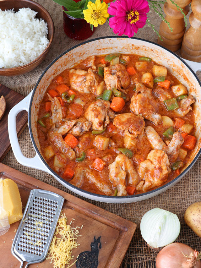 Chicken stewed in tomato sauce with carrots, potatoes, and bell pepper.