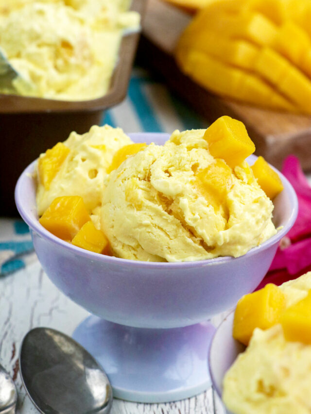 Homemade mango ice cream on dessert bowl with topped with mango cubes.